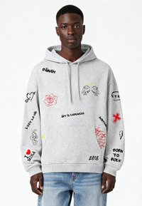 Felpa grigia in misto cotone. Presenta diverse grafiche ricamate tra cui rose, cuori e testo in nero e rosso. Tasca frontale.