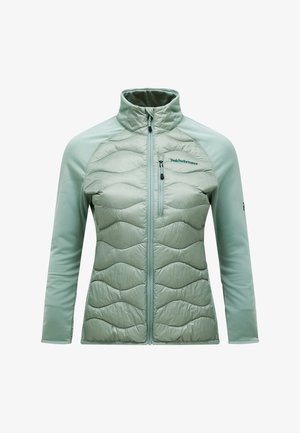 Lysegrøn jakke med blandet materialedesign: vatteret front med bølget tekstur og glatte ærmer. Fuldført lynlås og høj krave.