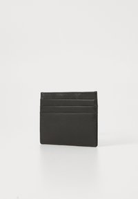 Porte-cartes en cuir noir avec quatre emplacements pour cartes, forme rectangulaire slim, texture lisse et finitions de couture soignées.
