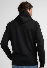 Sudadera con capucha negra de textura suave. Presenta mangas largas, un reverso liso y un dobladillo acanalado en la parte inferior.