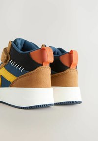 Hochschnittige Sneakers aus navyblauem Stoff, mit sandfarbenen Wildlederakzenten, orangefarbenem Zugtab, weißer Zwischensohle und kontrastierendem gelbem Logodetail.