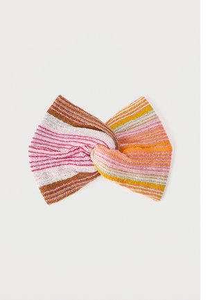 Gestricktes Stirnband mit gedrehtem Knoten in der Mitte, das horizontale Streifen in Pink-, Orange-, Gelb-, Grün-, Weiß- und Brauntönen auf weißem Hintergrund zeigt.