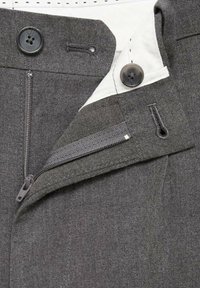 Talie de pantaloni gri cu o fermoar deschis, două butoane negre mari și găuri de buton vizibile pe căptușeala albă.