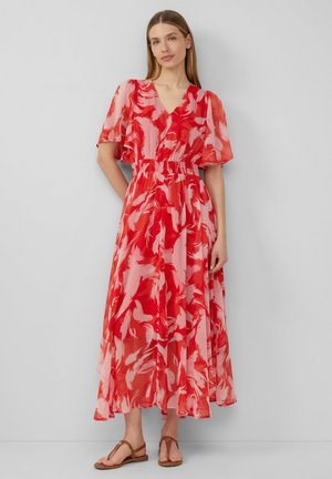 Robe maxi à motifs rouges et roses avec un décolleté en V, des manches courtes évasées, une taille élastique et un tissu fluide qui tombe jusqu'aux chevilles.