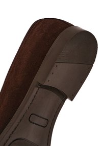 Brown shoe with a textured rubber sole. The upper is soft suede, and the heel features a smooth finish with visible stitching and accents.