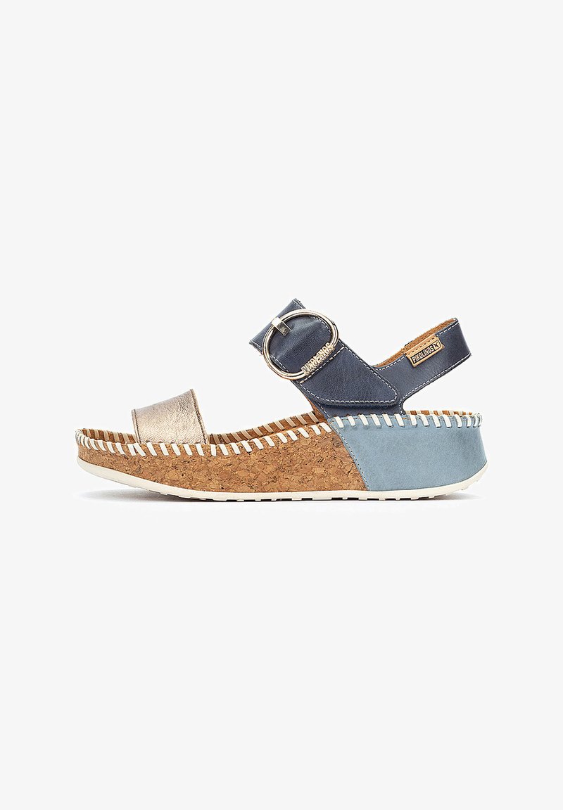 Sandalias con suela de corcho en cuña, que presentan una mezcla de cuero en tonos azul marino, dorado y azul claro. Correa ajustable con un hebilla redonda plateada.