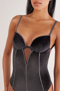 Body noir avec un tissu élégant, des panneaux en tissu résille transparent et des accents de strass argentés le long des bords. Comprend des bretelles réglables et des bonnets moulés.