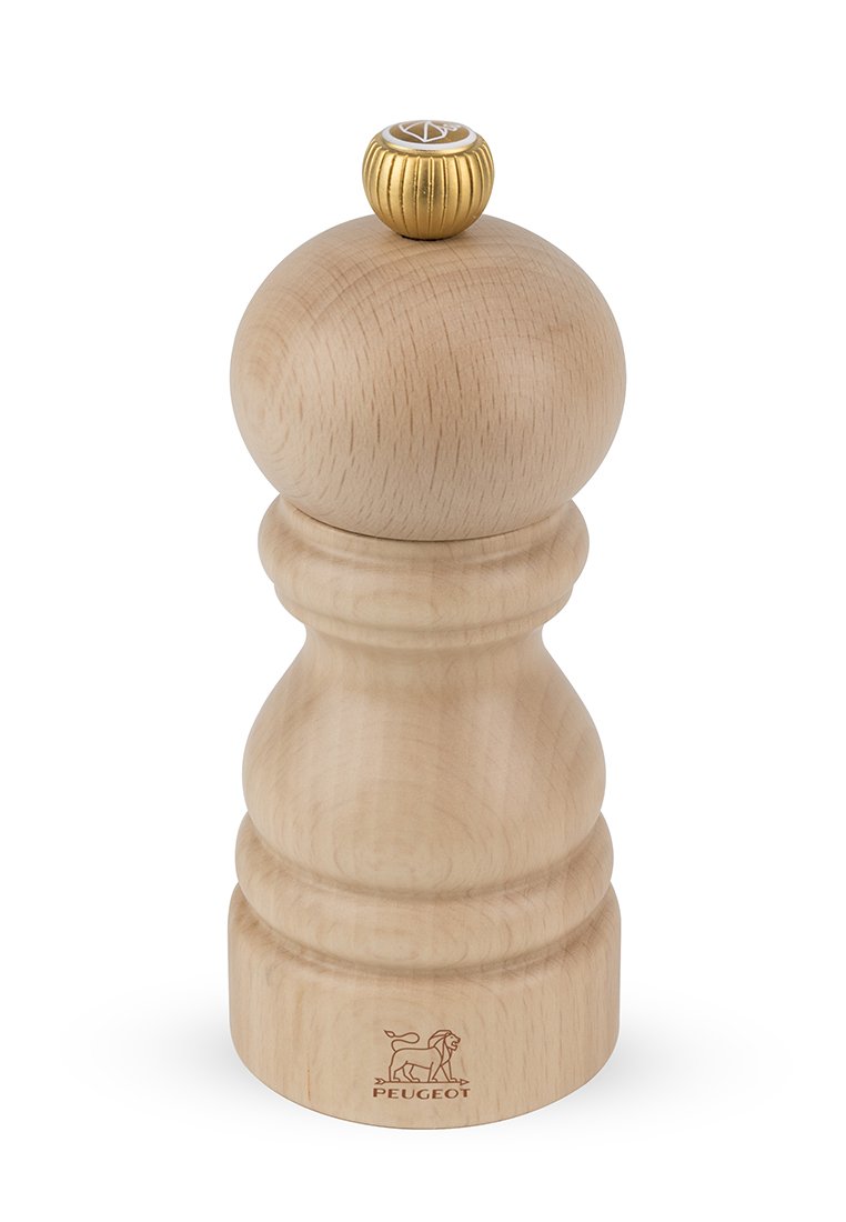 Holzmühle für Pfeffer mit runder Form, hellem Naturholzfinish, texturiertem goldenen Oberknopf und graviertem Peugeot-Logo nahe dem Sockel.