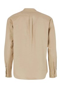Camicia beige a maniche lunghe con piega sul retro, polsini con bottoni e colletto classico. Il tessuto ha una finitura liscia e strutturata.