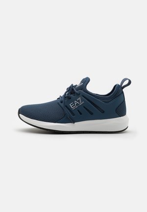 Granatowy sportowy but z siateczki z białą podeszwą, sznurowaniem, pętelką na pięcie i logiem EA7 Emporio Armani po boku.