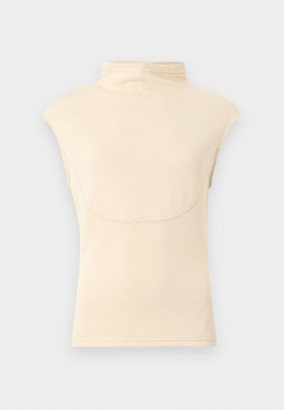 Ljusbeige ärmlös topp med hög krage, ribbad struktur och släta sömmar. Rundad bakre fåll med minimalistisk design.