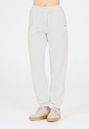 Lysegrå joggebukser med elastisk talje og manchetter ved anklerne, båret med beige platform-sneakers på en person mod en ensfarvet hvid baggrund.