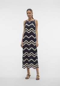 Abito senza maniche blu navy con motivo a ondine in pizzo color crema e dettagli con tagli; lunghezza midi e vestibilità rilassata, con sottili spalline.