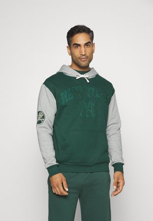 Sudadera con capucha de cuerpo verde oscuro y mangas grises, con "NEW YORK" bordado en el frente y un parche de logo en la manga.