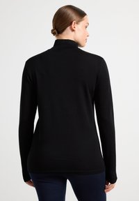 Sort langærmet top med høj krave og tætsiddende design. Fremstillet af et tekstureret, let materiale med et diskret strikket mønster.
