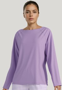 Lange mouwen top in licht lavendel, gladde stof, ronde hals, raglanmouwen, gecombineerd met geruite lavendelbroek.