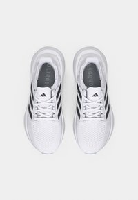 Valkoiset urheilukengät mustilla yksityiskohdilla, joissa verkkomateriaalia päällä, nauhallinen kiinnitys ja pehmustettu kaulus, kielessä teksti "ULTRABOOST".