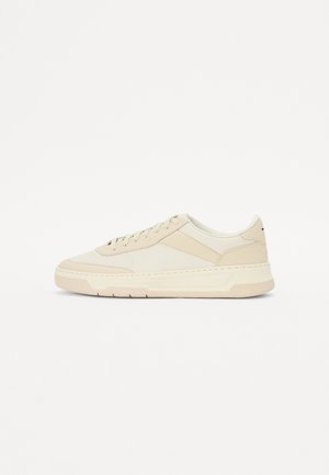 Beige sneakers laget av glatt lær og tekstil; lavprofil design med rund tå og snøring; teksturerte sideakenter.