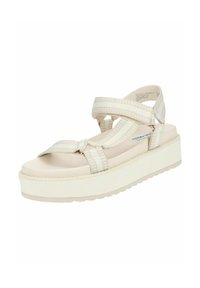 Sandali platform beige chiaro con cinturini intrecciati a incrocio, una soletta liscia e una suola in gomma testurizzata. Dettagli includono una punta rotonda.