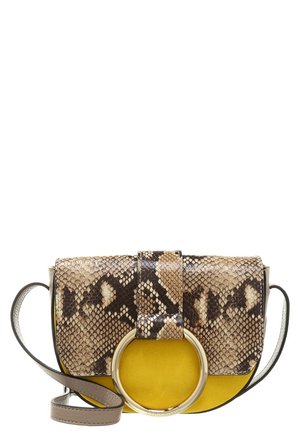 Crossbody-taske med gul ruskindsbund, slangeprintklap, stor guldringdetalje og grå justerbar læderrem.