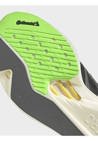 Semelle de chaussure avec bande de roulement en caoutchouc vert et gris, trous de ventilation et logo de la marque Continental sur la partie verte près du talon.