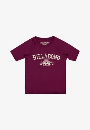 Bordowa koszulka z krótkim rękawem Billabong rash guard z białym napisem „BILLABONG since 1973” i logo fali na przodzie.