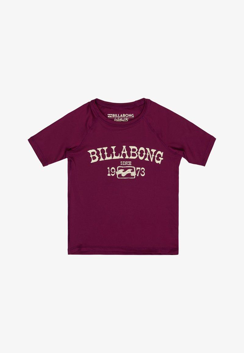 T-shirt Rash guard Billabong à manches courtes couleur marron avec texte blanc "BILLABONG depuis 1973" et logo vague sur le devant.