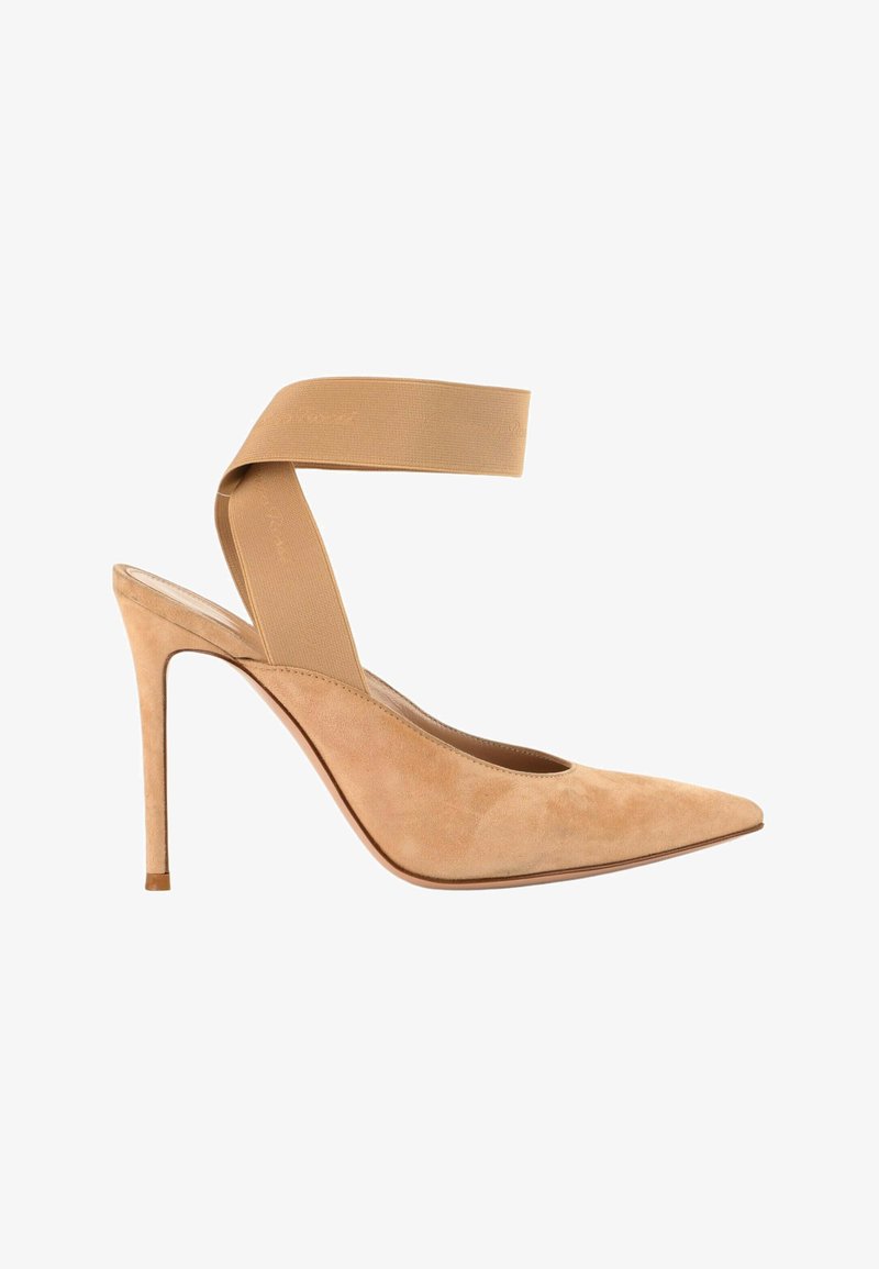 Chaussure à talons hauts en daim beige avec bout pointu et large bride élastique enveloppant la cheville pour le soutien.