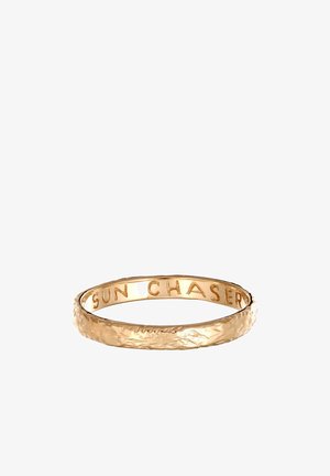 Goldfarbener Ring mit einer strukturierten Außenseite und einem glatten Innenband, das mit "SUN CHASER" graviert ist, und einem zarten, minimalistischen Design.