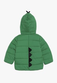 Giacca imbottita verde con cappuccio, caratterizzata da un design a squame nere testurizzate e un breve accento nero nella parte superiore.