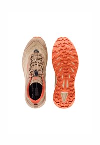 Scarpe da trail running beige con tomaia in mesh texturizzato, accenti arancioni e suola impugnata dotata di tasselli multidirezionali per la trazione.