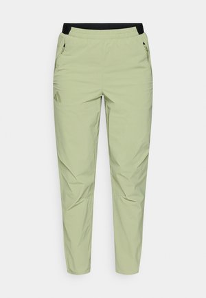 Világoszöld, keskenyedő nadrág fekete rugalmas derékpánttal, cipzáras zsebekkel és logóval a bal lábszáron. Simább, könnyű anyag.