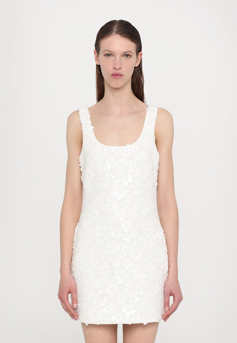 White sleeveless dress with a scoop neckline, featuring floral appliqué details, a fitted silhouette, and a textured fabric finish.