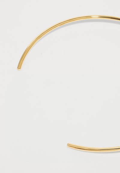 Dünner, offener Gold-Metallarmreif mit glatten, abgerundeten Kanten auf einem weißen Hintergrund.