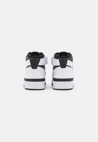 Høje sneakers med en overdel i hvid læder, sorte detaljer og en polstret krave. Har en bageste rem og en kontrasterende hvid sål.