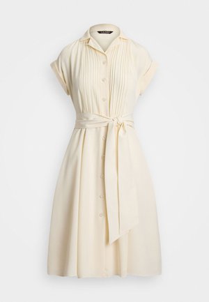 Vestido amarelo claro com mangas curtas, frente abotoada, detalhes plissados e um laço na cintura. Tecido suave com uma saia até ao joelho.
