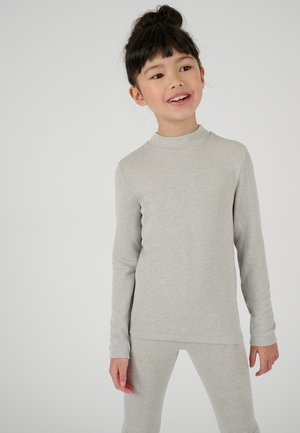 Top grigio chiaro a maniche lunghe con collo alto e tessuto testurizzato, abbinato a leggings grigi chiari coordinati, entrambi aderenti e lineari.
