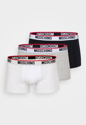 Trois paires de boxer en blanc, gris et noir. Chacune présente une ceinture élastique noire et rouge avec le logo "MOSCHINO". Matière en coton doux.