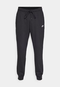 Pantalones deportivos negros de Nike con cintura elástica, cordón ajustable, tobillos con puños y pequeño logo blanco de Nike en el muslo izquierdo.
