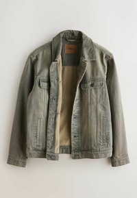 Džinsa jaka olīvu zaļā krāsā ar pogu aizdari, divām krūšu kabatām un iekšpuses zamšādas līdzīgu oderi. Aprīkota ar klasisku apkakli un nelielu tekstūru.