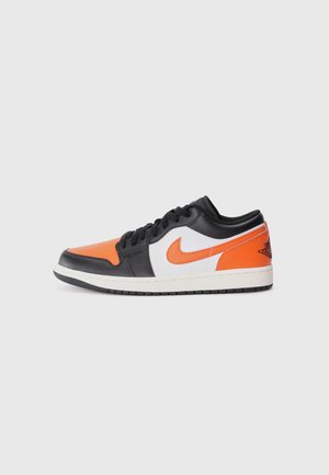 Black and orange leather low-top sneakers with white accents, featuring a textured surface, black laces, and a rubber sole.