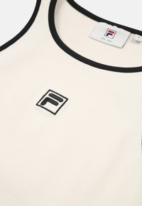 Vit ribbad linne med svart kant och Fila-logotyp centrerad på bröstet, med rund halsringning och en texturerad yta.