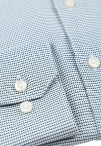Blauw-wit gestreepte shirt met een houndstooth ontwerp, voorzien van knoopmanchetten en parelachtige knopen. Katoenen stof met een gladde textuur.