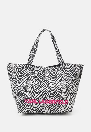 Duża torba typu tote w czarno-białe paski zebry z napisem "KARL LAGERFELD" w wyraźnych różowych literach na przedzie.