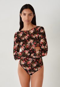 Zwarte kanten bodysuit met lange mouwen, met een bloemenpatroon in roze en rode tinten, versierd met een gegolfde halslijn en randen.