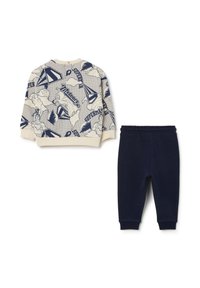 Sudadera de algodón con base crema y estampado de superhéroes en navy, combinada con pantalones de chándal de algodón navy que cuentan con una cinturilla elástica.