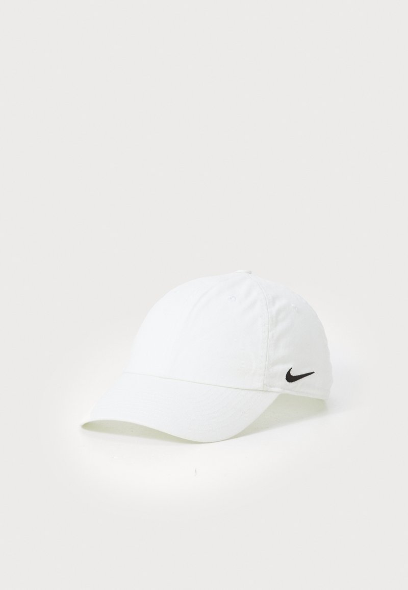 Biała bawełniana czapka baseballowa z zakrzywionym daszkiem, z czarnym logo Nike z boku oraz widocznymi detalami przeszycia.