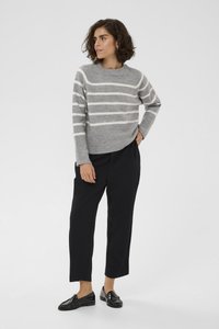 Pull gris à rayures avec ourlet côtelé, associé à un pantalon noir et des mocassins brillants. Texture douce avec une coupe décontractée et un col rond.
