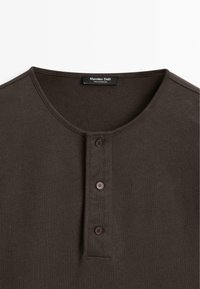 Dunkelbraunes Henley-Shirt mit Rundhalsausschnitt und drei Knöpfen an der Vorderleiste, Etikett zeigt "Massimo Dutti" und "Hergestellt in Portugal".