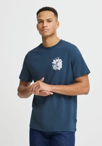 Mörkblå bomullströja med rund halsringning, korta ärmar och vit grafisk design som föreställer ordet "GROW" och blommönster.